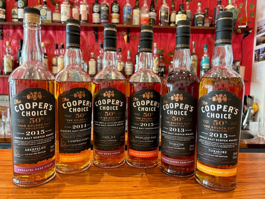 Lineup of 6 Cooper's Choice Golden Cut whisky bottles on a bar